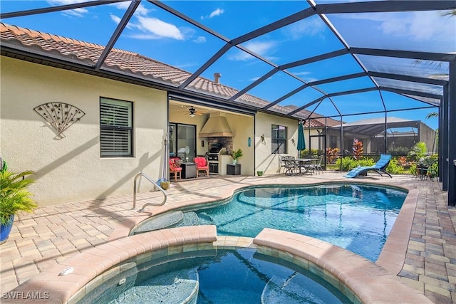 view of swimming pool with a lanai, an in ground hot tub, ceiling fan, and a patio