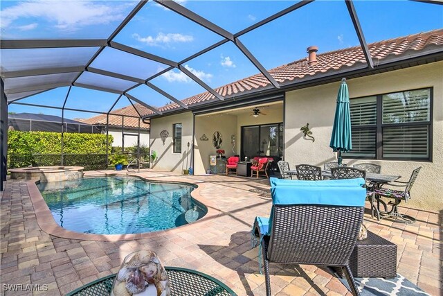 view of pool featuring a lanai, a patio area, ceiling fan, and an in ground hot tub