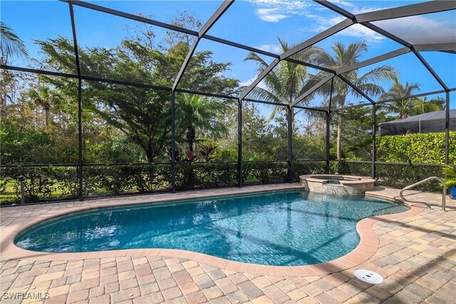 view of pool featuring an in ground hot tub, glass enclosure, and a patio area