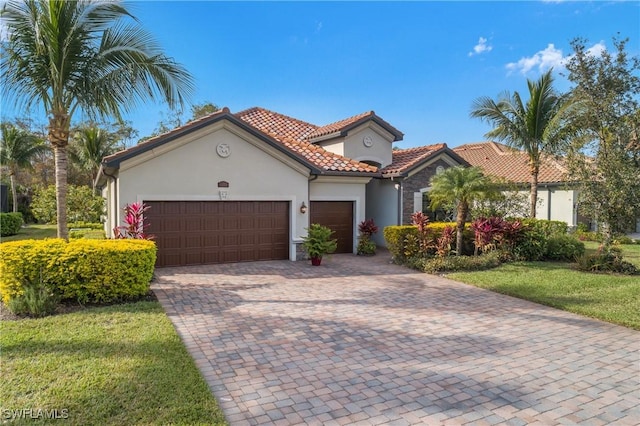 mediterranean / spanish-style house featuring a garage and a front lawn