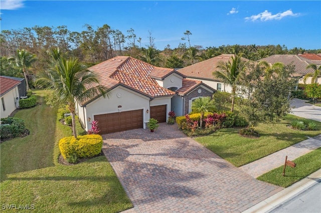 mediterranean / spanish home with a garage and a front yard