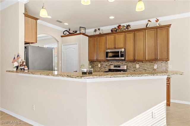 kitchen featuring kitchen peninsula, appliances with stainless steel finishes, hanging light fixtures, and ornamental molding