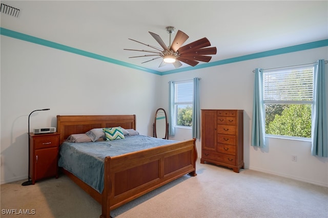 carpeted bedroom featuring ceiling fan and crown molding