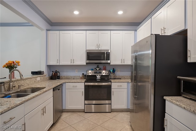 kitchen with light stone counters, ornamental molding, stainless steel appliances, sink, and white cabinetry