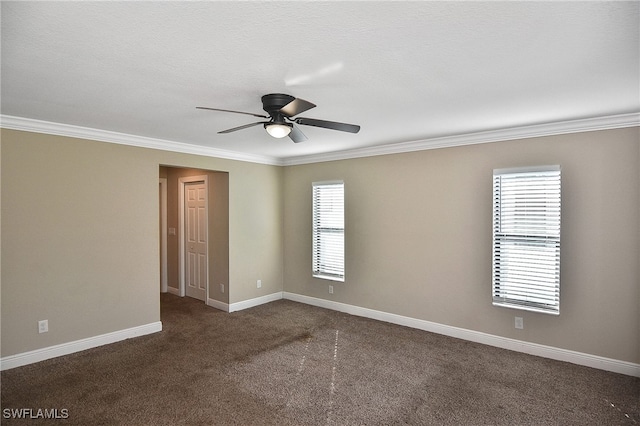 empty room with ceiling fan, a healthy amount of sunlight, ornamental molding, and dark carpet