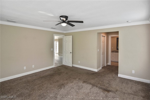 spare room with dark colored carpet, ceiling fan, and crown molding