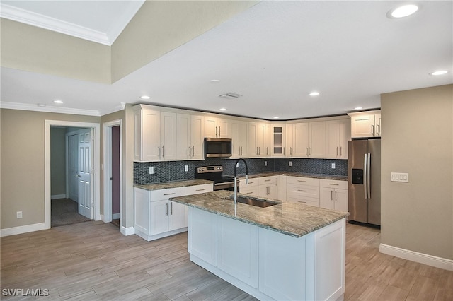 kitchen featuring backsplash, crown molding, sink, an island with sink, and stainless steel appliances