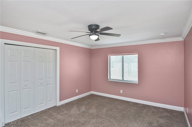 unfurnished bedroom featuring carpet flooring, ceiling fan, crown molding, a textured ceiling, and a closet