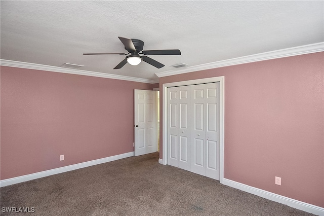 unfurnished bedroom with carpet, a textured ceiling, ceiling fan, crown molding, and a closet