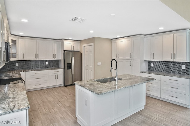 kitchen featuring sink, white cabinets, black appliances, and light hardwood / wood-style floors