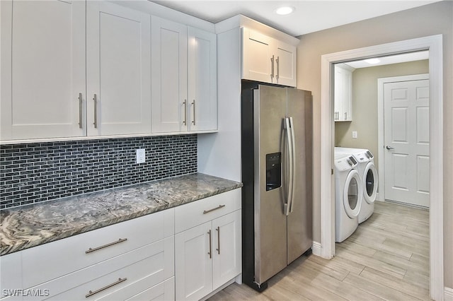 washroom with cabinets, washing machine and dryer, and light hardwood / wood-style flooring