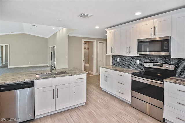 kitchen with light stone countertops, white cabinetry, sink, appliances with stainless steel finishes, and light wood-type flooring