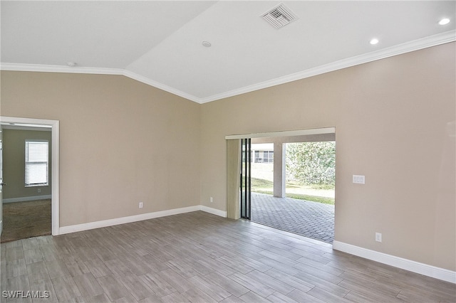 empty room featuring vaulted ceiling, light hardwood / wood-style flooring, and a wealth of natural light