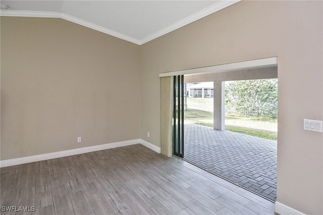 unfurnished room with hardwood / wood-style floors, lofted ceiling, and crown molding