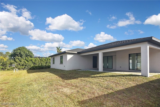 back of property featuring a patio area and a yard