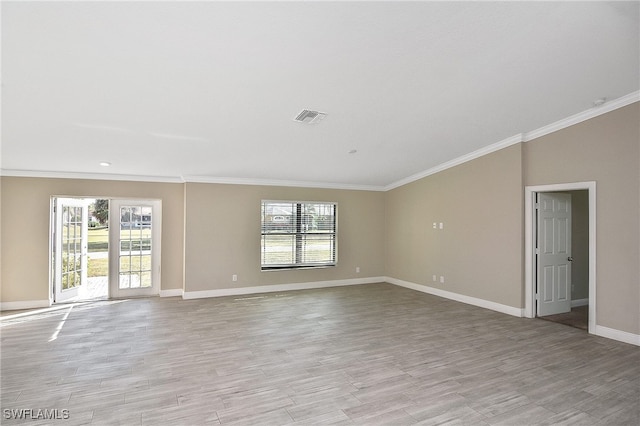 empty room with light hardwood / wood-style floors and crown molding