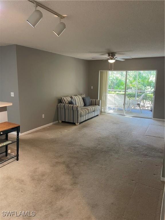 carpeted living room with a textured ceiling, rail lighting, and ceiling fan