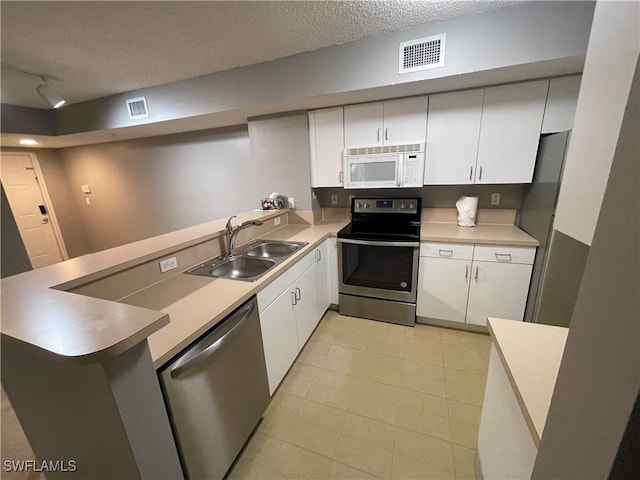 1885 Florida Club Dr Unit 8108, Naples, FL 34112 - kitchen featuring appliances with stainless steel finishes, a peninsula, a textured ceiling, and white cabinets