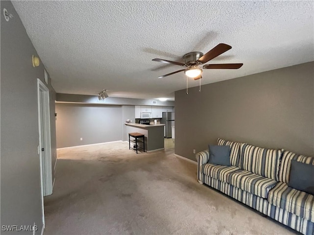 living room with carpet, a textured ceiling, and ceiling fan