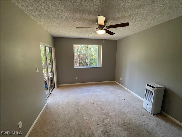 spare room featuring light carpet, a textured ceiling, and ceiling fan