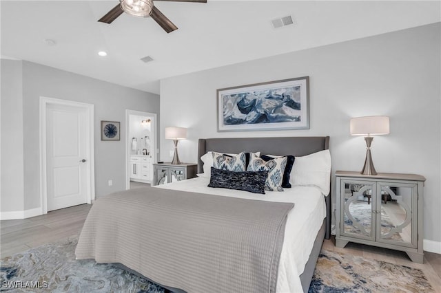 bedroom featuring light wood-type flooring, connected bathroom, visible vents, and a ceiling fan