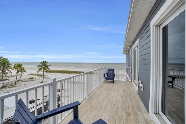 balcony featuring a beach view and a water view