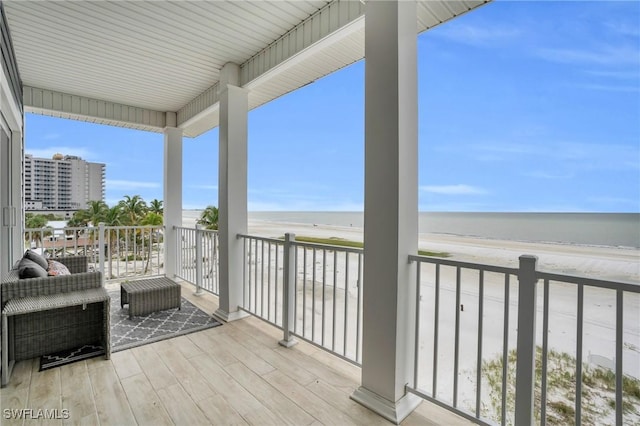 balcony with a water view and a beach view