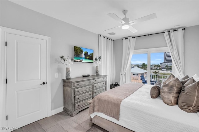 bedroom featuring ceiling fan, wood finish floors, visible vents, baseboards, and access to outside