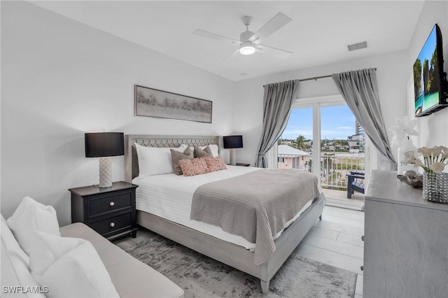 bedroom featuring a ceiling fan, access to outside, visible vents, and wood finished floors