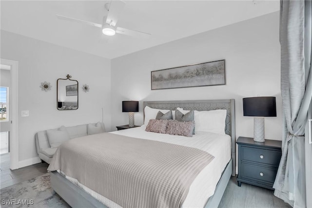 bedroom with light wood-type flooring, a ceiling fan, and baseboards