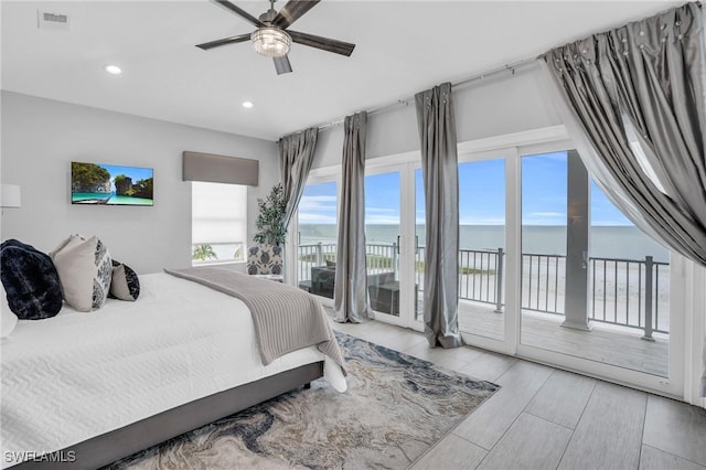 bedroom with access to outside, recessed lighting, a water view, visible vents, and light wood-type flooring