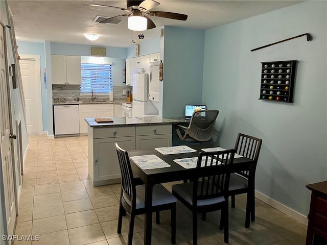 tiled dining space featuring ceiling fan and sink