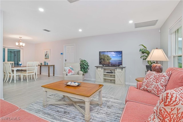 living room with light hardwood / wood-style flooring and a chandelier