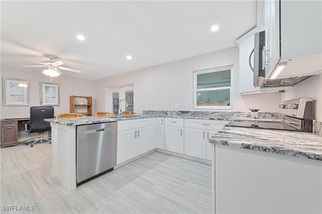 kitchen featuring white cabinetry, sink, light stone counters, kitchen peninsula, and appliances with stainless steel finishes