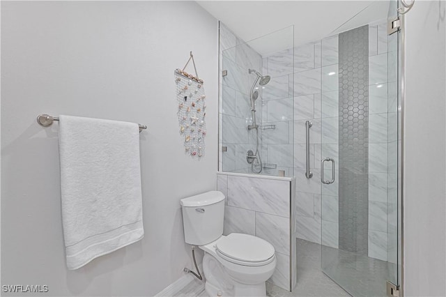 bathroom featuring a shower with door and toilet