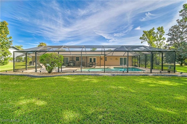 rear view of house with a lawn and glass enclosure