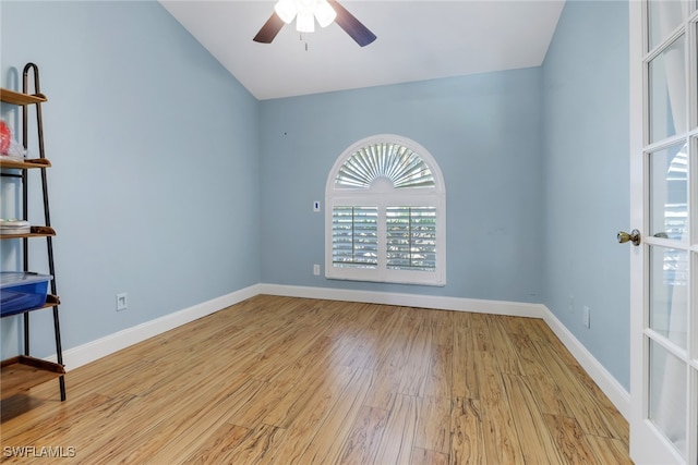 unfurnished room with ceiling fan, lofted ceiling, and light wood-type flooring