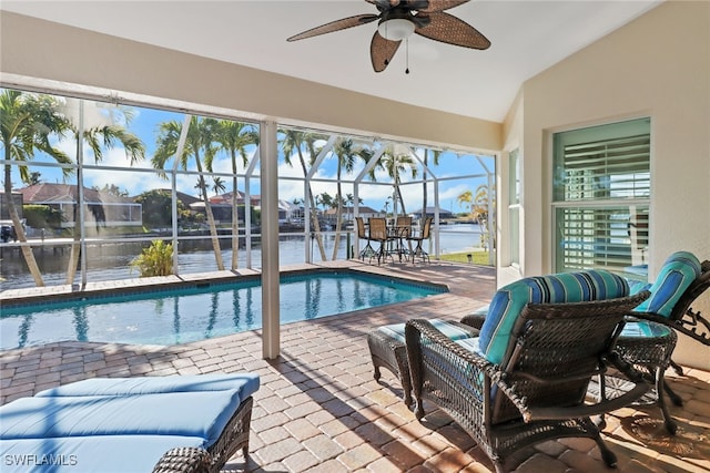 view of pool featuring a lanai, a water view, ceiling fan, and a patio area