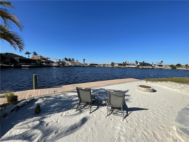 view of dock featuring a water view and an outdoor fire pit