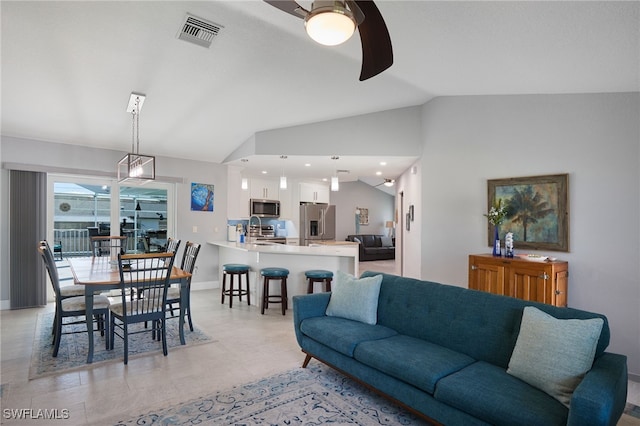 living room featuring ceiling fan, sink, and vaulted ceiling