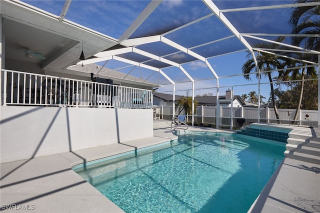 view of swimming pool featuring a patio, ceiling fan, and a lanai