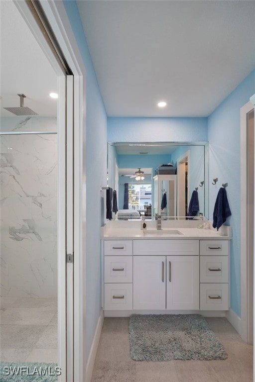 bathroom featuring tile patterned flooring, vanity, and a tile shower