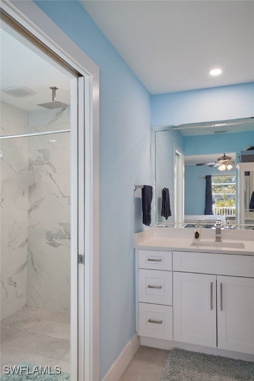 bathroom with vanity, ceiling fan, and a tile shower