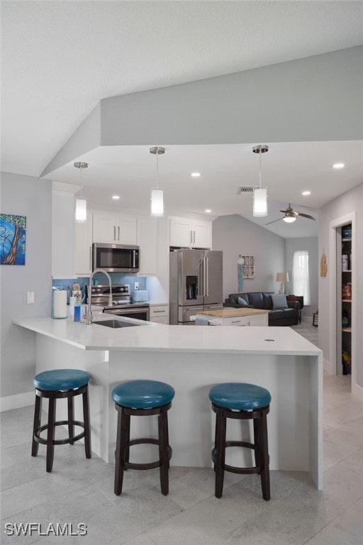 kitchen featuring white cabinets, ceiling fan, lofted ceiling, and stainless steel appliances