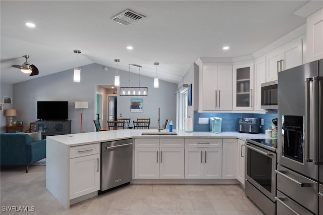 kitchen with white cabinets, stainless steel appliances, lofted ceiling, and sink