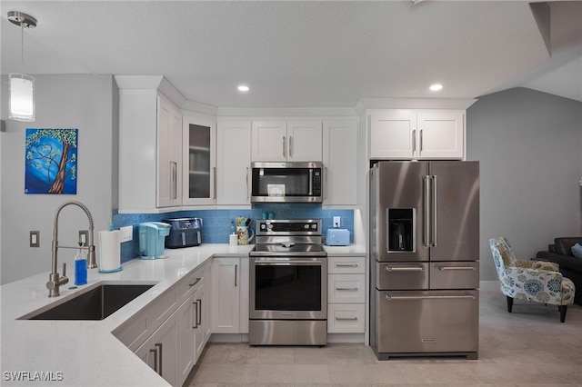 kitchen with white cabinets, stainless steel appliances, and decorative light fixtures