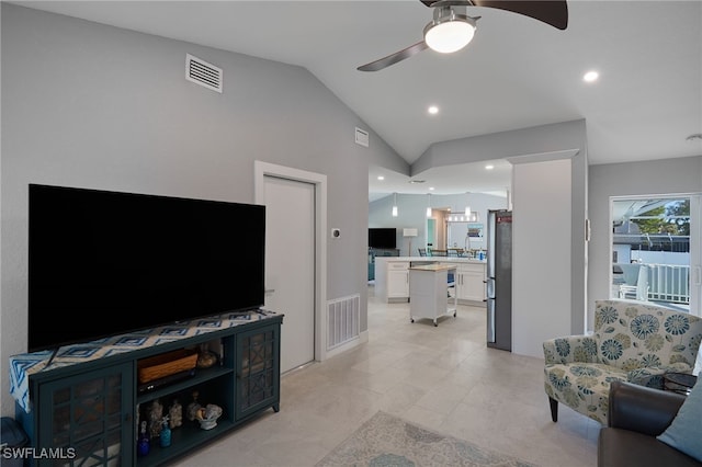 tiled living room featuring ceiling fan and vaulted ceiling