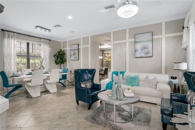 tiled living room featuring ceiling fan with notable chandelier, crown molding, and a healthy amount of sunlight