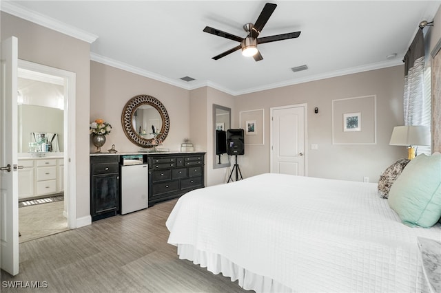 bedroom featuring ceiling fan, white refrigerator, ornamental molding, and ensuite bathroom