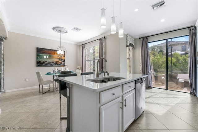 kitchen with a wealth of natural light, sink, hanging light fixtures, and an island with sink